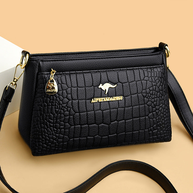 Black crocodile pattern crossbody purse for every occasion with gold-tone kangaroo logo and detachable strap