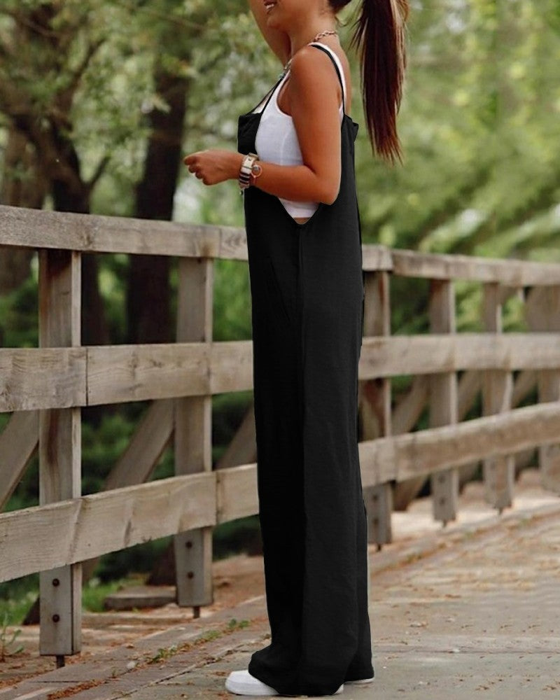 Woman wearing black fashion jumpsuit for women with wide legs and white tank top outdoors