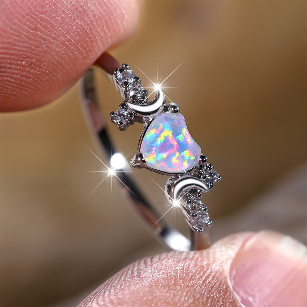 Moonstone love ring featuring a heart-shaped moonstone with crescent moons and sparkling stones