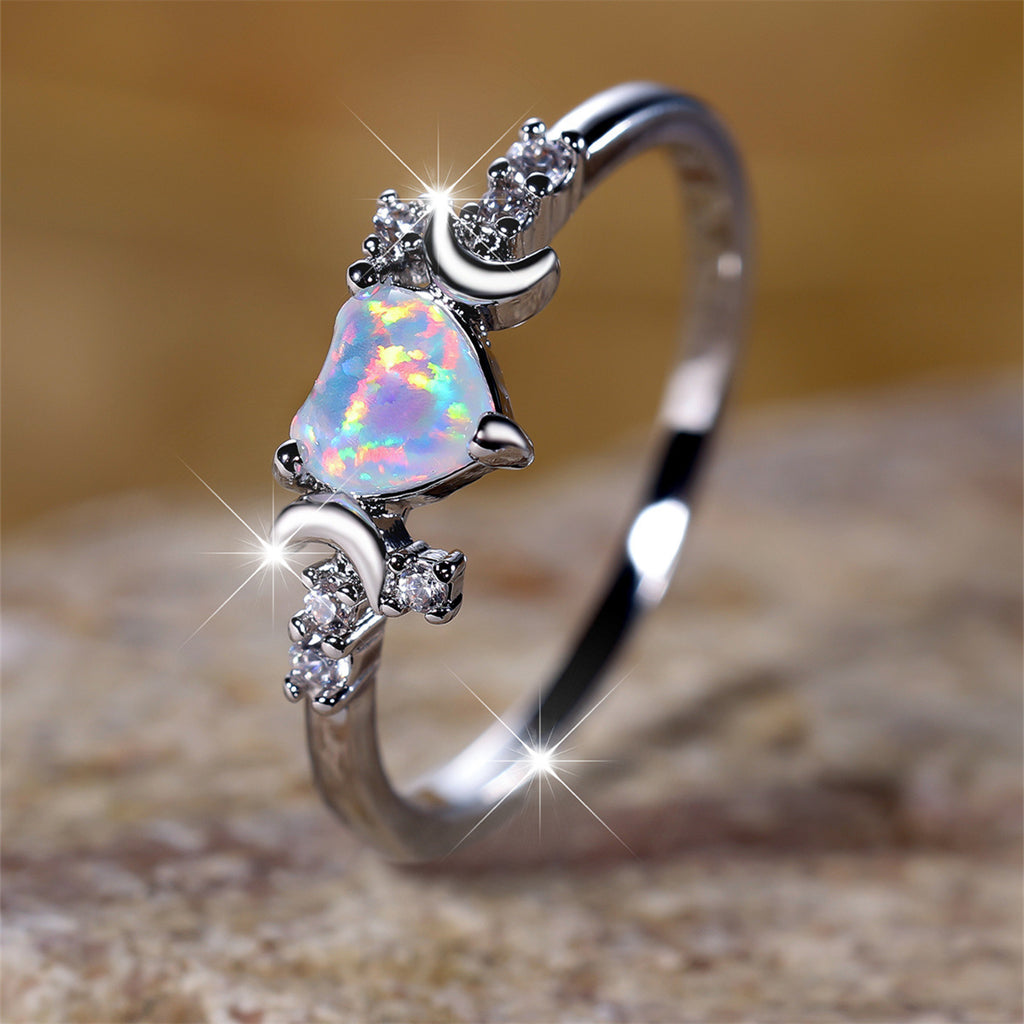 Silver moonstone love ring with heart-shaped opal and crescent moon accents sparkling on band