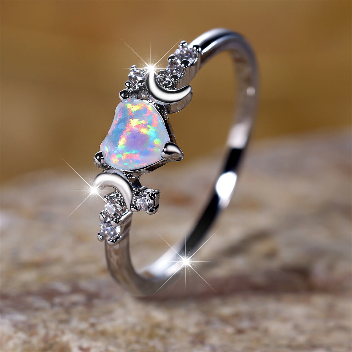 Silver moonstone love ring with heart-shaped opal and crescent moon accents sparkling on band
